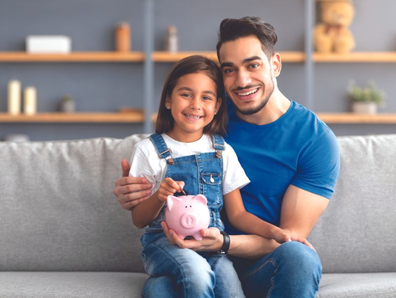 dad daughter with a piggy bank