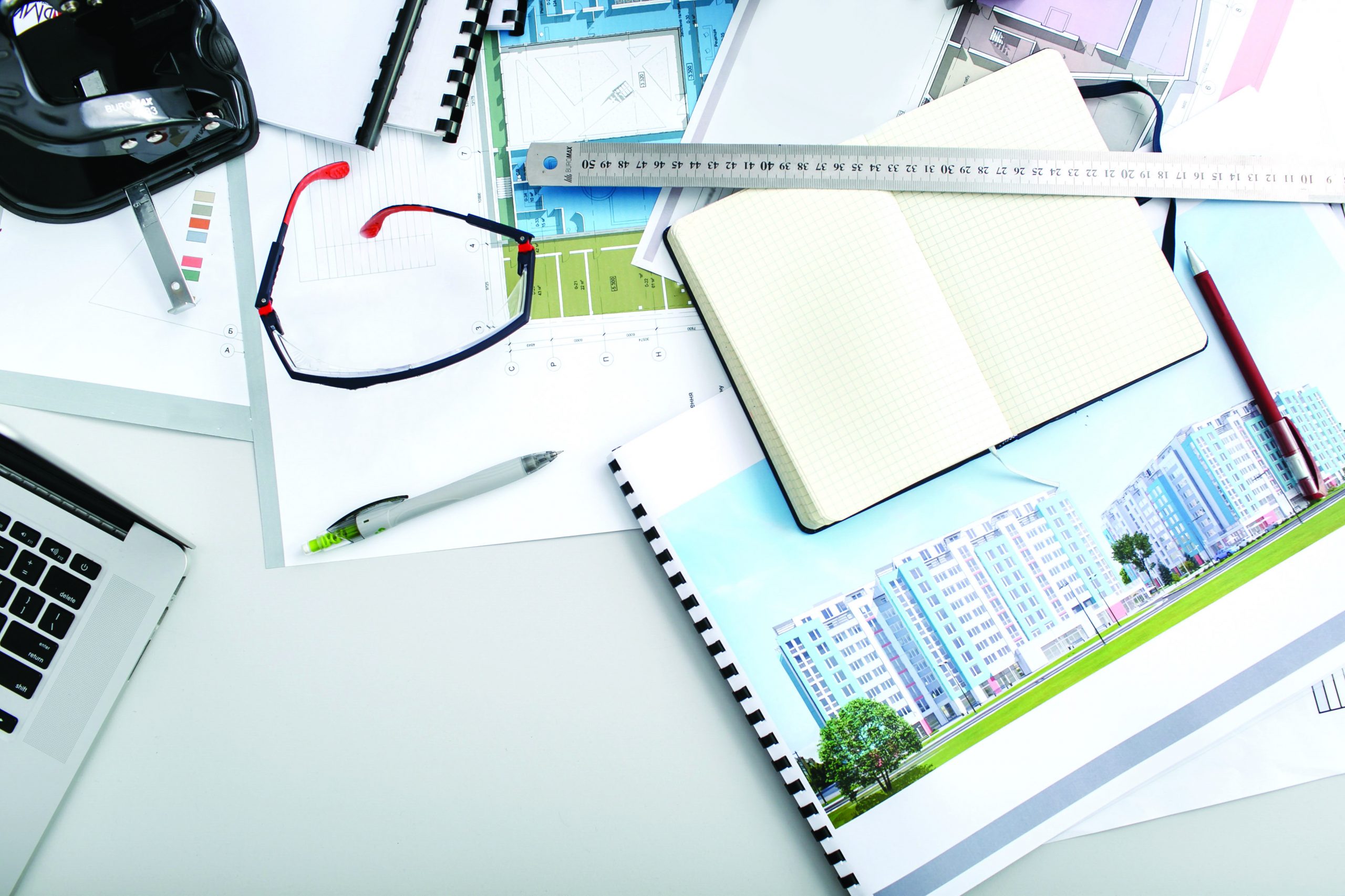 Maps, notebook, ruler and pens lie on office table