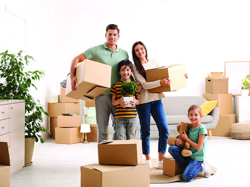 Happy,Family,In,Room,With,Cardboard,Boxes,On,Moving,Day