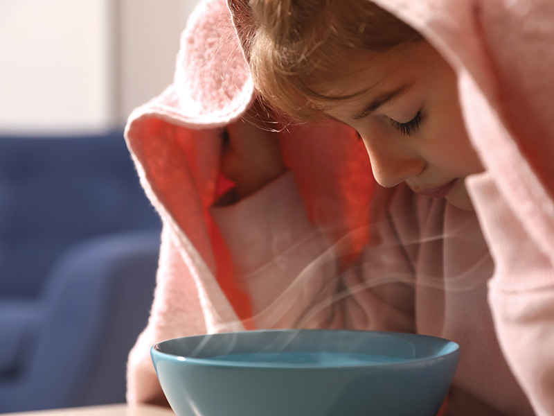 Little,Girl,Covering,Head,With,Towel,And,Inhaling,Steam,Indoors,