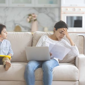 Tired,Young,Indian,Freelance,Mom,Working,From,Home,,Reading,Paper