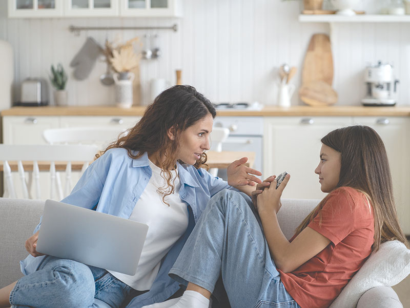 Confused,Teenage,Girl,Looking,At,Mother,Scolding,For,Using,Mobile