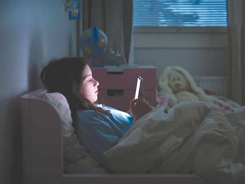 A,Child,Using,Smart,Phone,Lying,In,Bed,Late,At