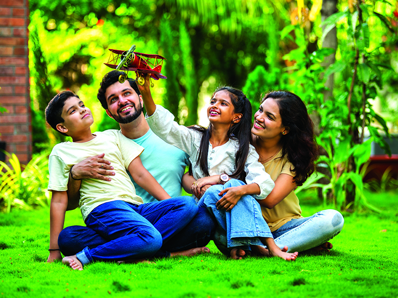 Joyful,Indian,Couple,With,Their,Kids,Sitting,In,A,Park,